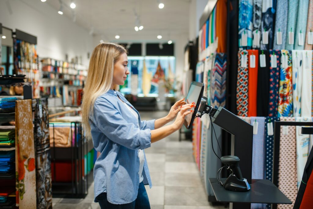 Saleswoman at cash register in textile store