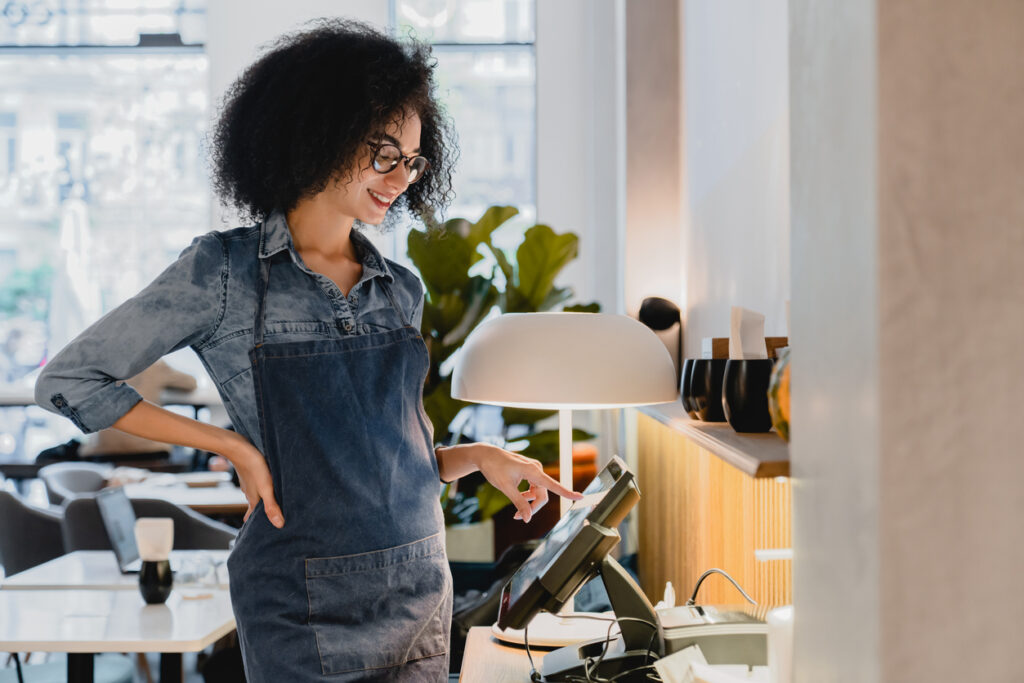 Commerçant utilisant une caisse enregistreuse avec terminal de paiement intégré pour une gestion rapide