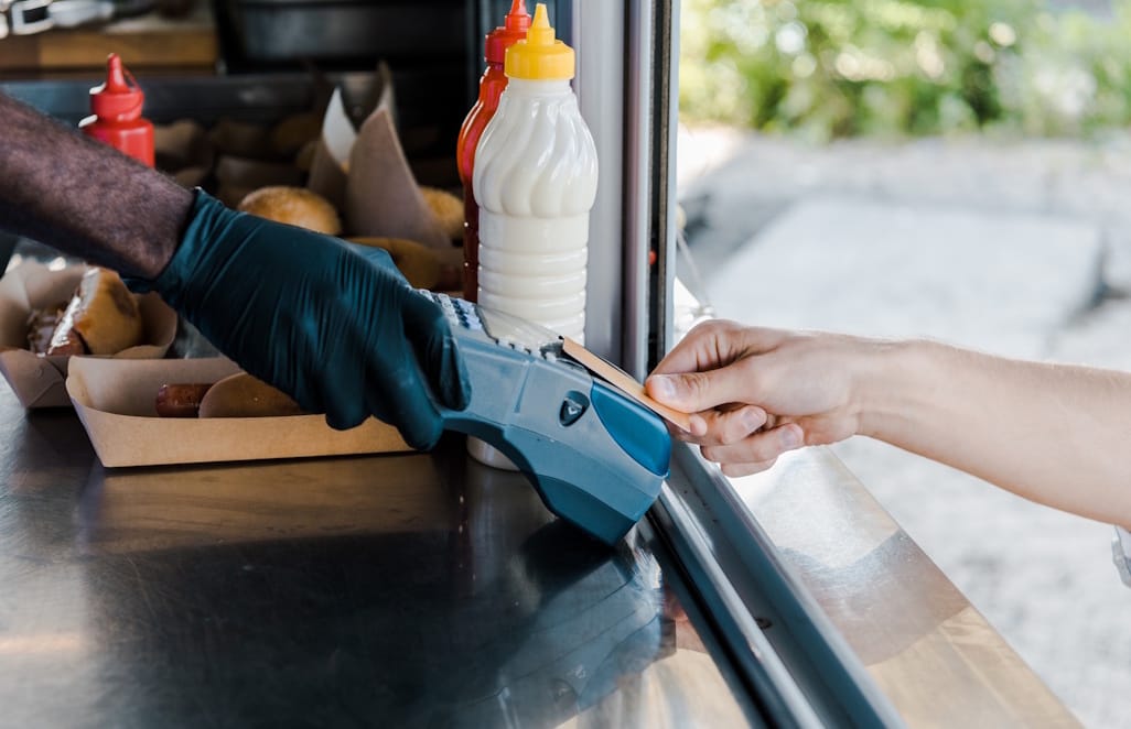 Client effectuant un paiement sans contact dans un food truck avec terminal mobile