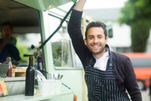 Un patron de food truck souriant en tablier