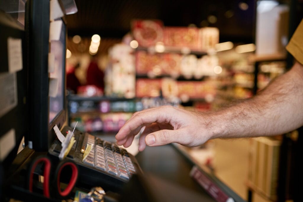Gros plan sur la main d'un commerçant se servant d'une caisse enregistreuse