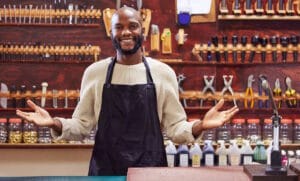 Commerçant-artisan souriant derrière son comptoir