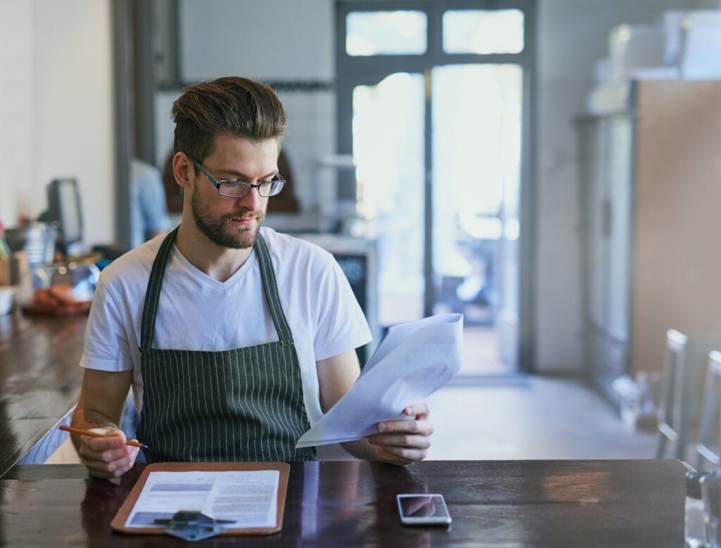 Jeune artisan sérieux vérifiant la conformité de son logiciel de caisse