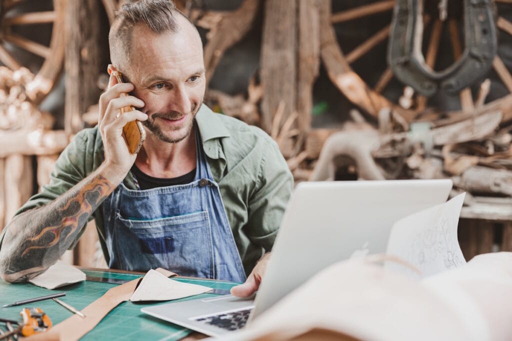 Artisan souriant téléphone à son prestataire de contrat monétique